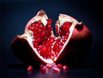 A pomegranate is cut open and ready to be eaten.