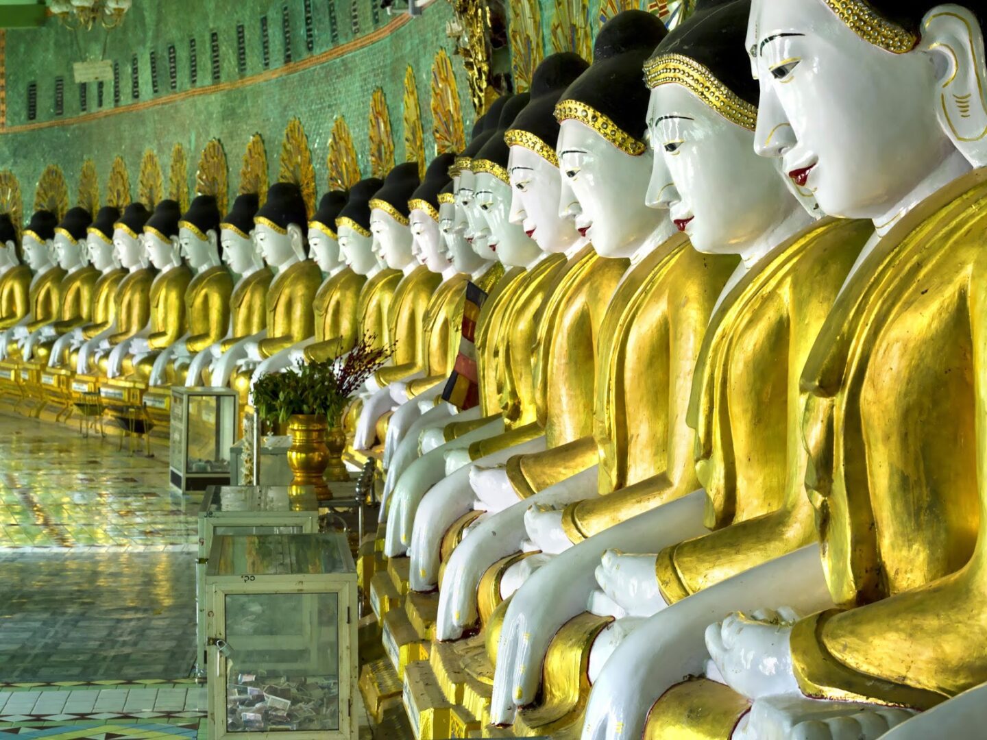 Row of golden Buddha statues in a temple.